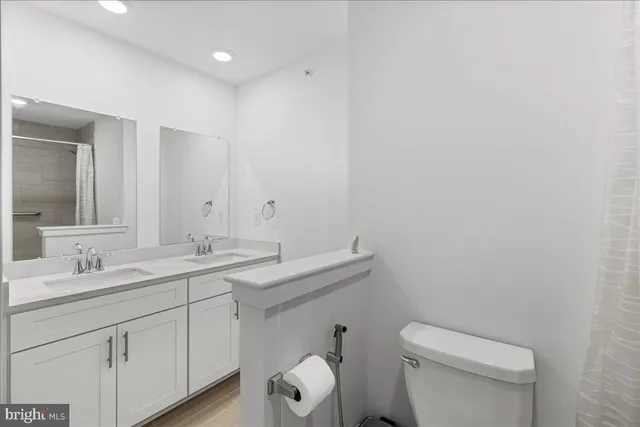 a bathroom with a toilet a sink and mirror