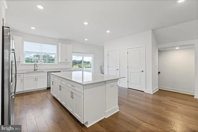 a kitchen with white cabinets stove and sink