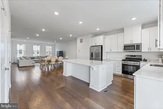 a open kitchen with white cabinets and stainless steel appliances