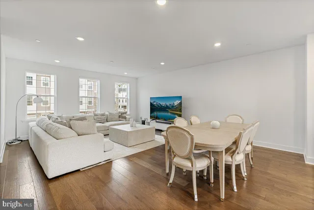 a living room with furniture a wooden floor and a flat screen tv