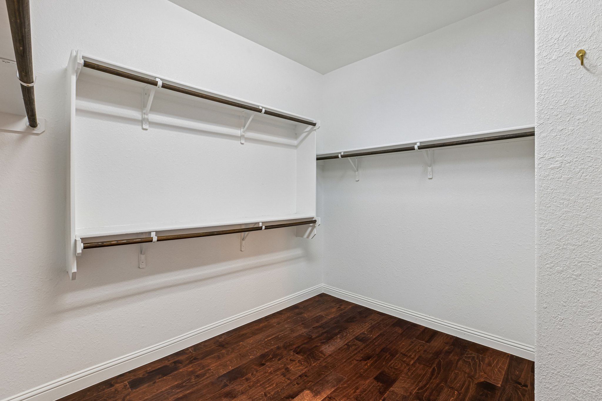 1924 Granite Springs Road Leander, TX 78641 - Photo 18 of 36 Two Large Walk in Closets located in the Primary Bedroom! Ample hanging space and rich hardwood floors define this well-appointed closet, ready for personalized organization.