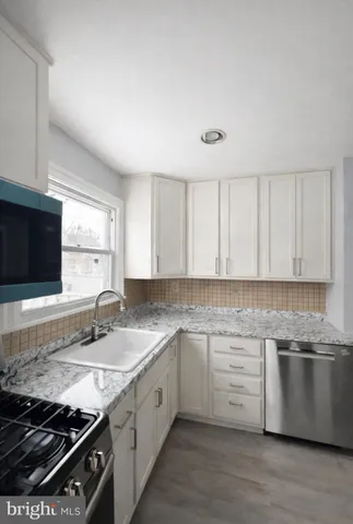 a kitchen with stainless steel appliances granite countertop a sink stove and cabinets
