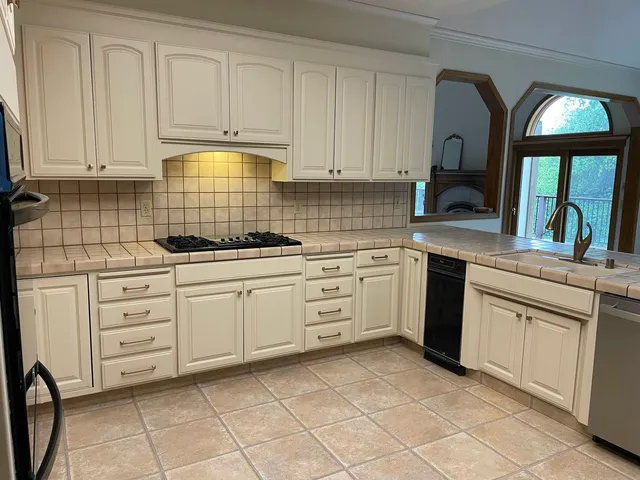 a kitchen with white cabinets stainless steel appliances and sink