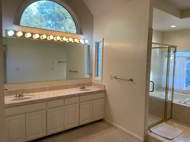 a spacious bathroom with a granite countertop sink and a mirror