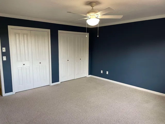 a view of an empty room with a chandelier fan