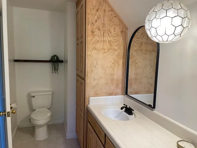 a bathroom with a sink a toilet and a mirror