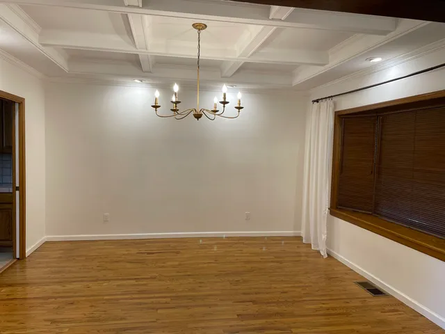 a view of a room with a ceiling fan and wooden floor