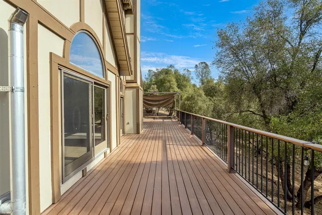a view of a balcony with wooden floor and fence