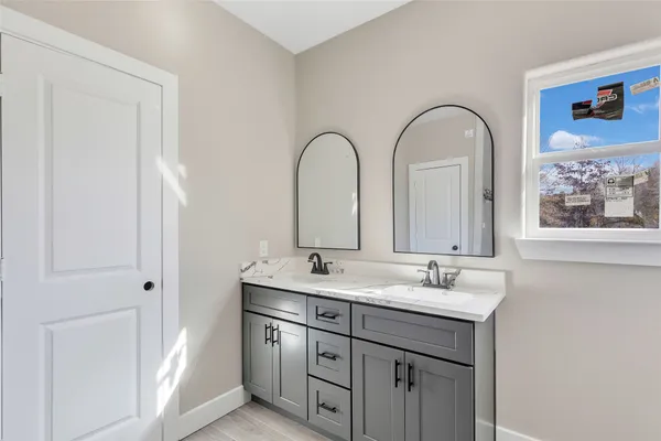 a bathroom with a double vanity sink and a mirror