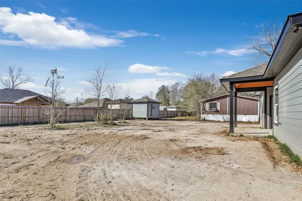 a view of dirt yard with a large tree