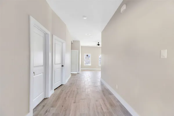 a view of a hallway with wooden floor