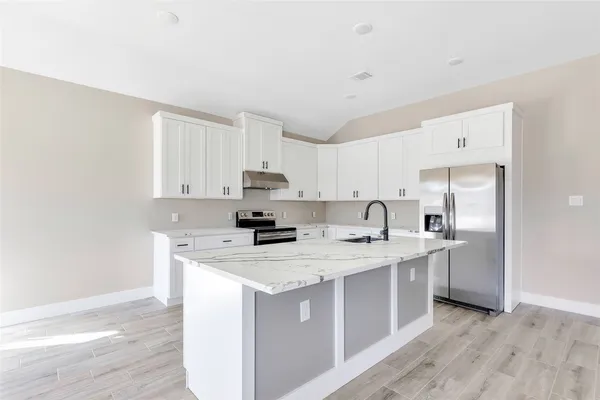 a kitchen with stainless steel appliances granite countertop a sink stove and refrigerator