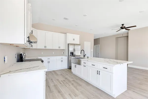 a kitchen with a sink stove and white cabinets