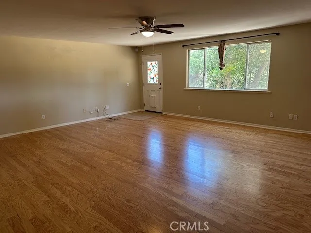 a view of an empty room with wooden floor and closet