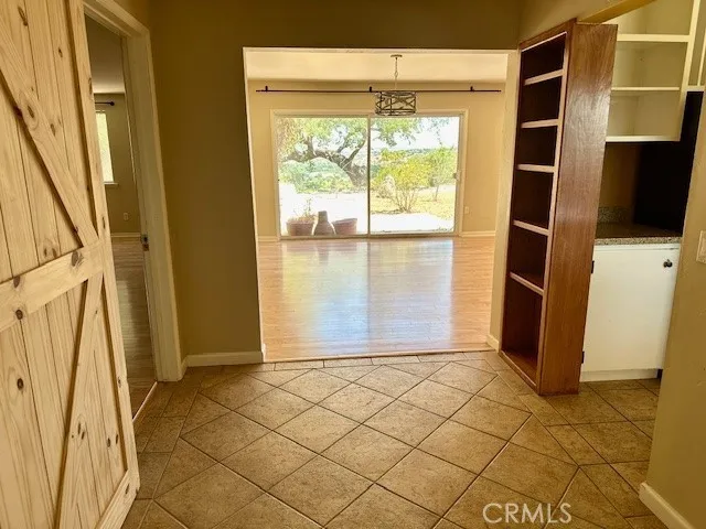 a view of an empty room with wooden floor fireplace and a window