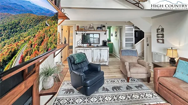 a living room with furniture a rug and a painting on the wall