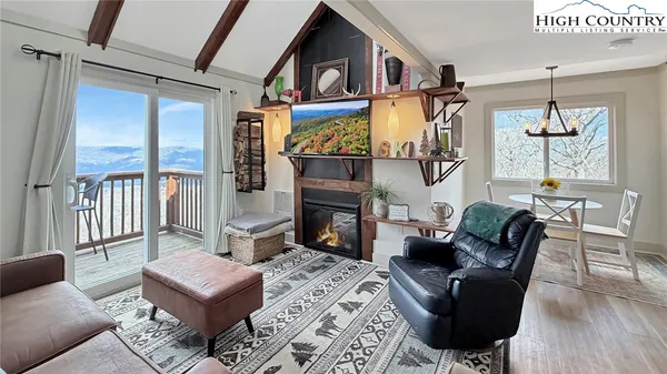 a living room with furniture a fireplace and a floor to ceiling window