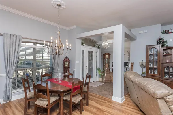 a living room with furniture a chandelier and a dining table