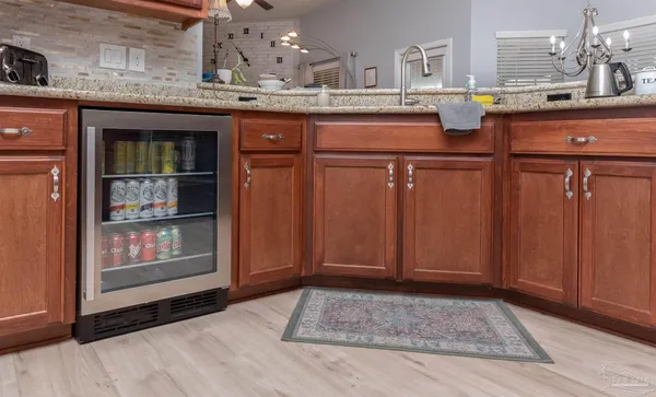 a living room with stainless steel appliances granite countertop wooden cabinets and a counter top space