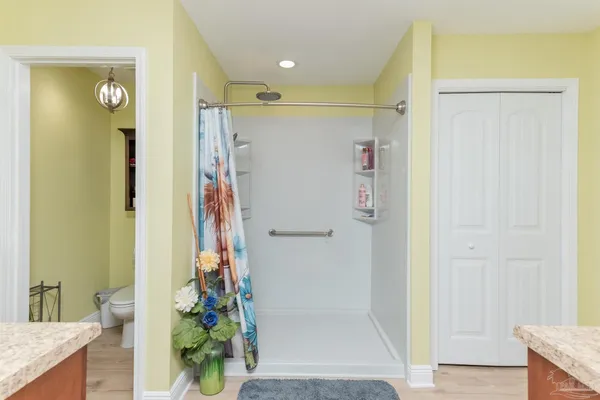 a bathroom with a granite countertop shower a sink and a mirror