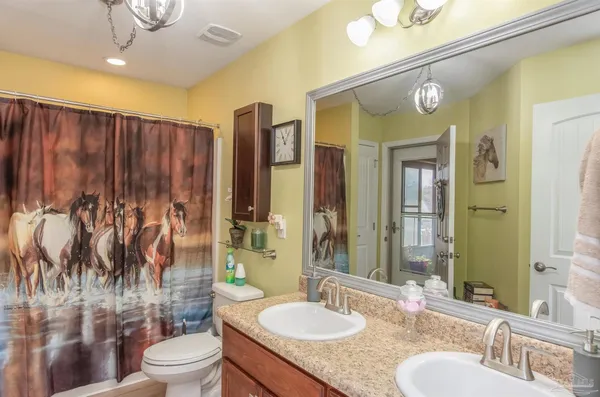 a bathroom with a granite countertop toilet sink and mirror