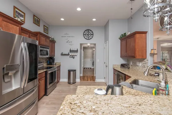 a kitchen with stainless steel appliances granite countertop a refrigerator and a sink