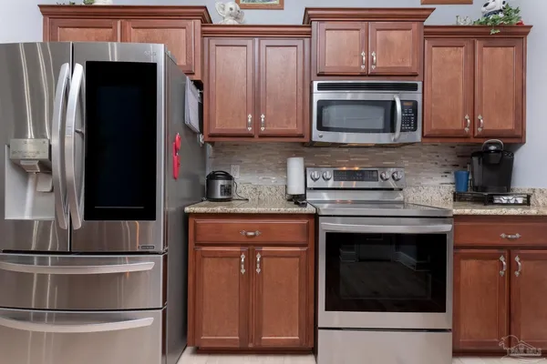 a kitchen with stainless steel appliances granite countertop a stove microwave and refrigerator