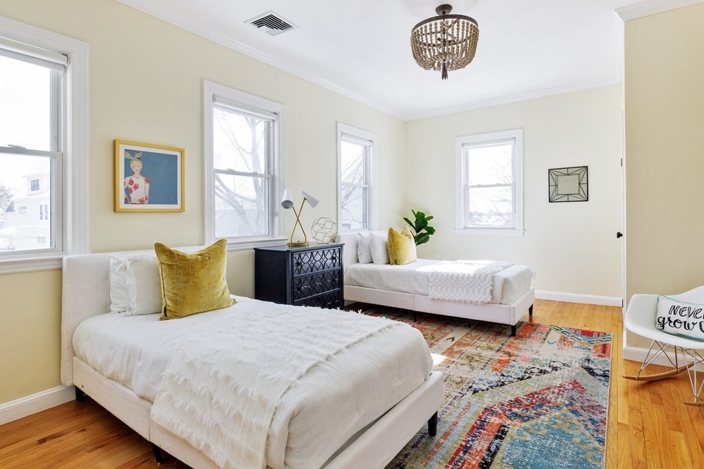 24 Adams Street, Unit 5 Somerville, MA 02145 - Photo 13 of 28 a bedroom with a bed and wooden floor