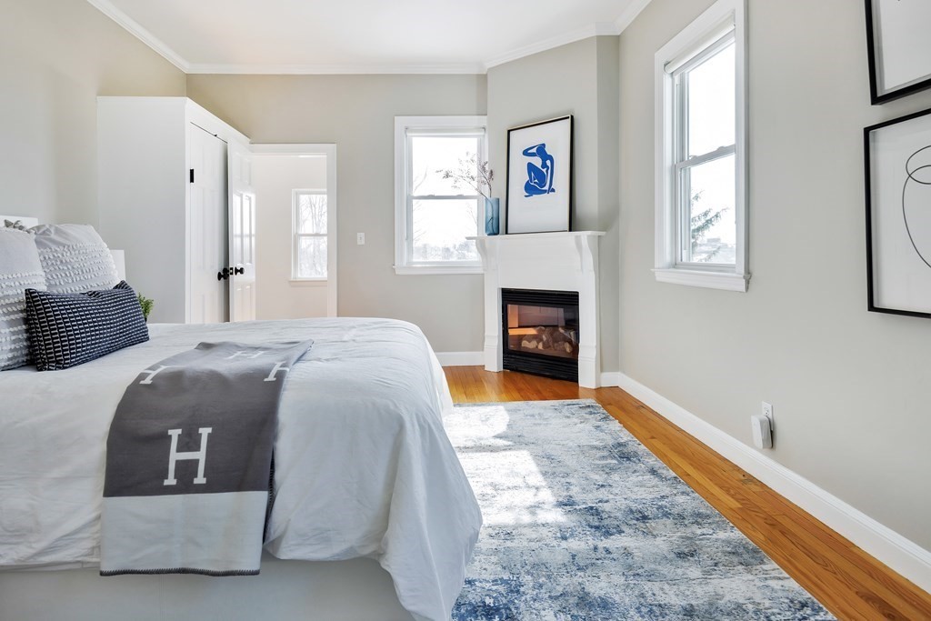 24 Adams Street, Unit 5 Somerville, MA 02145 - Photo 16 of 28 a bedroom with a bed and a fireplace