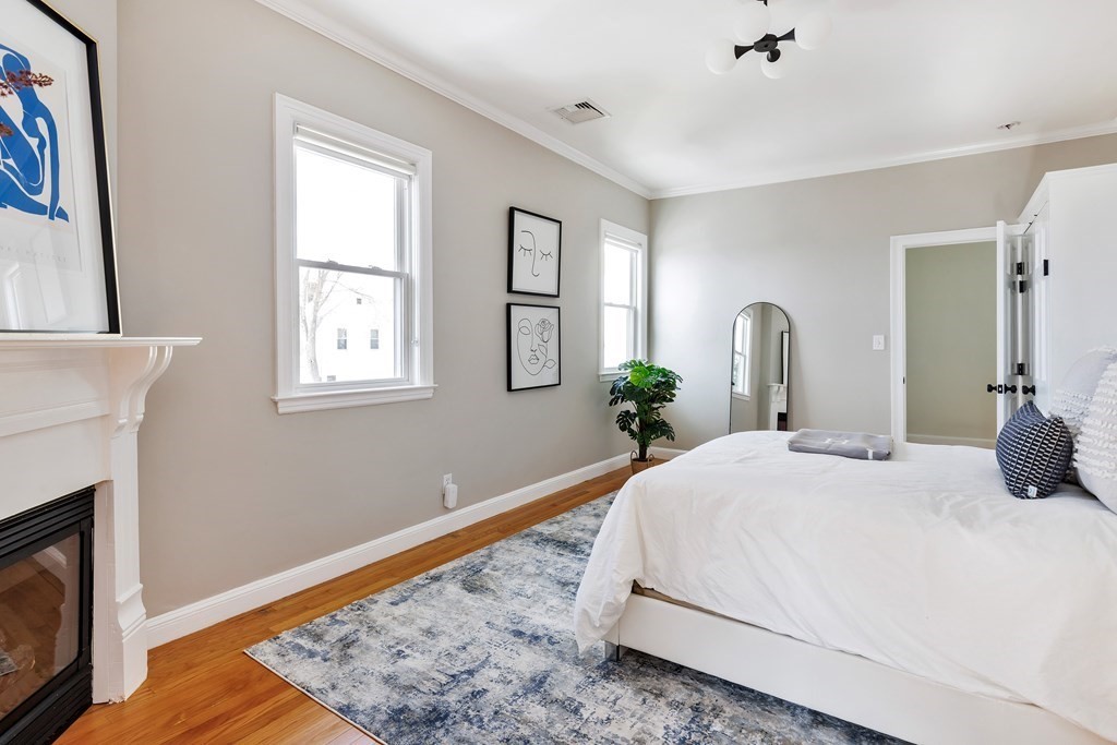 24 Adams Street, Unit 5 Somerville, MA 02145 - Photo 18 of 28 a bedroom with a bed wooden floor and window