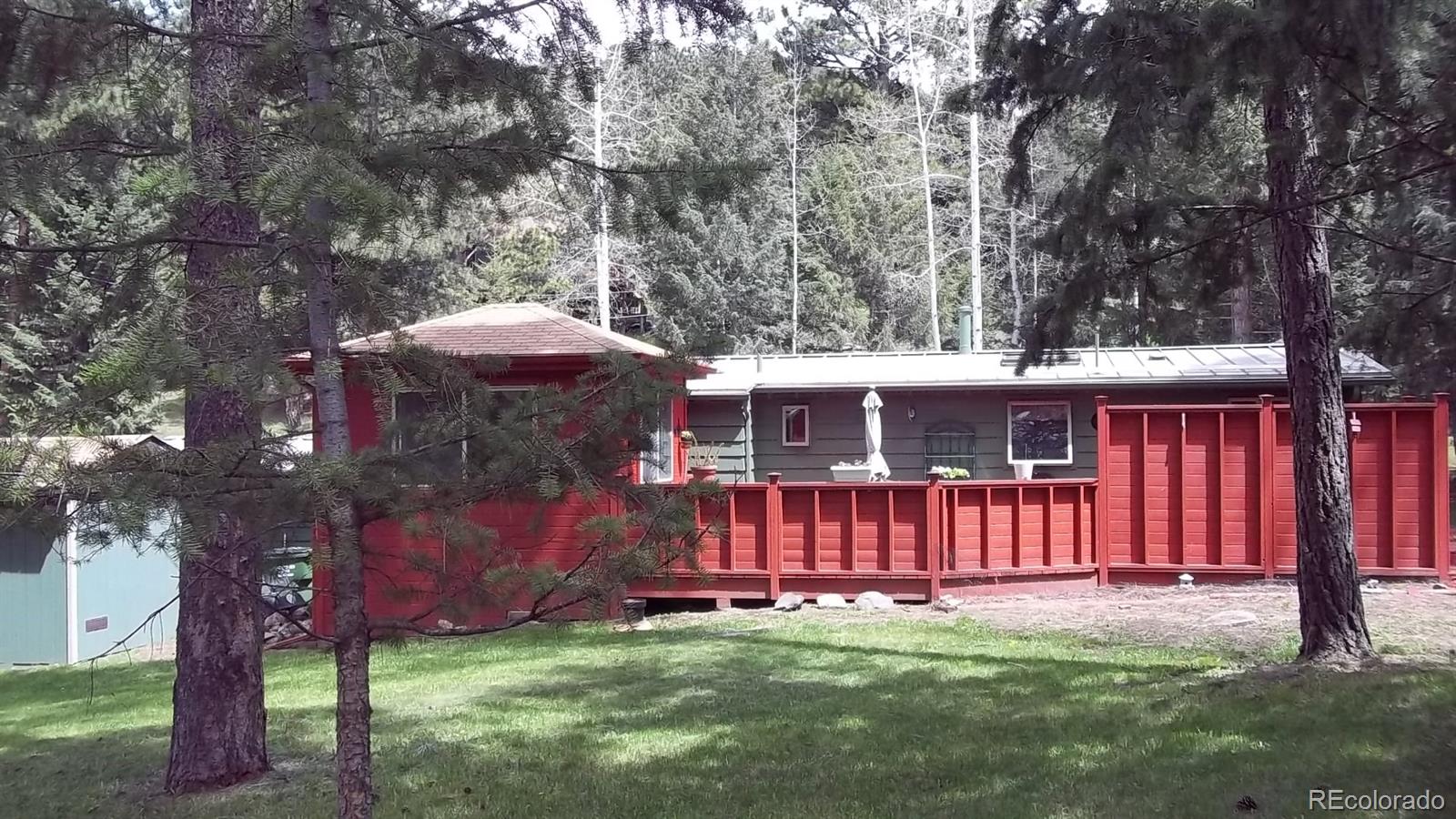1017 Valley Road Evergreen, CO 80439 - Photo 3 of 17 a view of a yard with large trees and a barn in it