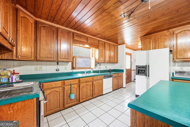 a kitchen with stainless steel appliances granite countertop a sink a stove counter space and cabinets