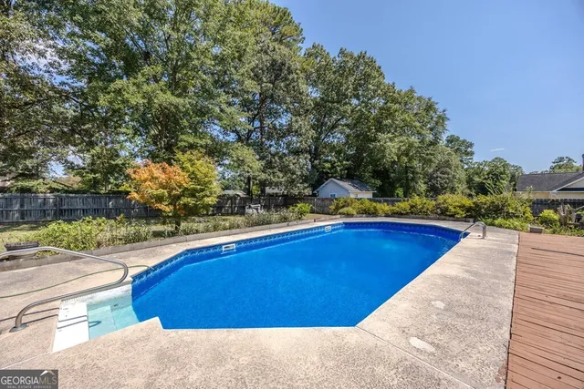 a swimming pool with outdoor seating and yard