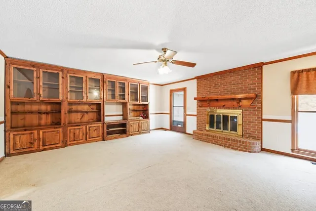 a view of an empty room with a fireplace and cabinet
