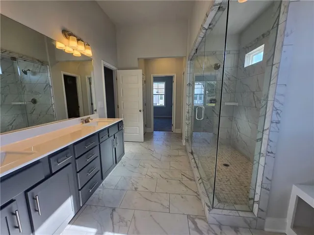 a bathroom with a double vanity sink toilet and shower