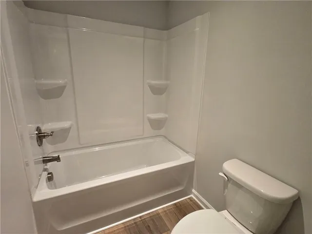 a bathroom with a toilet and a bath tub