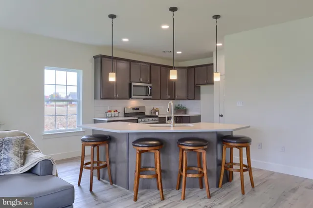 a kitchen with a sink a window and chairs
