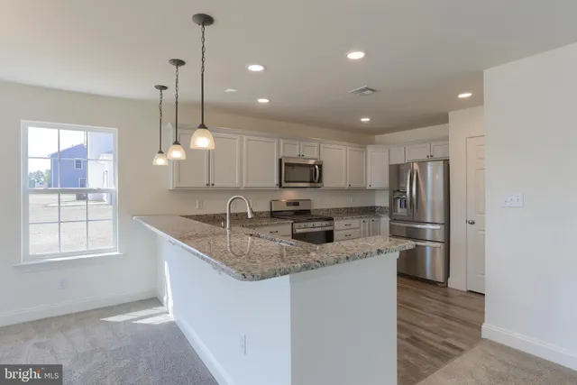 a kitchen with stainless steel appliances granite countertop a sink refrigerator and microwave