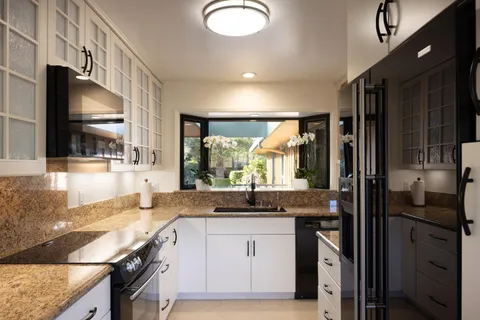 a kitchen with granite countertop a sink stove and refrigerator