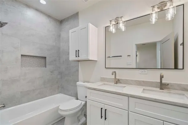 a bathroom with a granite countertop sink a toilet and a bathtub