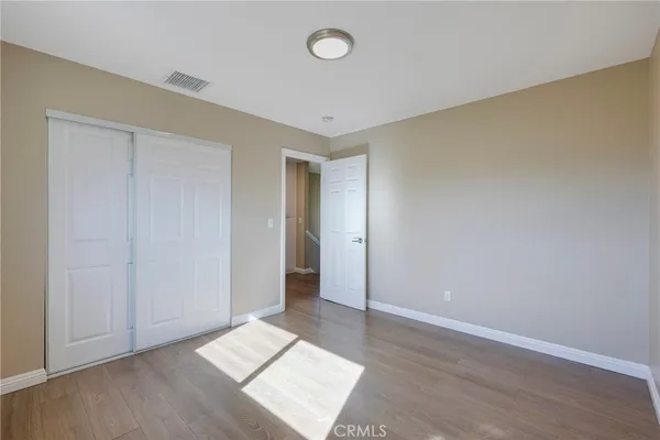 an empty room with wooden floor and window