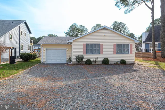 a view of a house with a yard and large tree