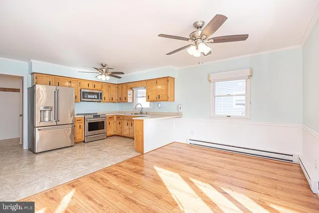 a kitchen with stainless steel appliances kitchen island a refrigerator sink and cabinets