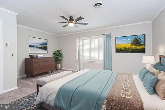 a bedroom with a bed a painting on the wall and a window