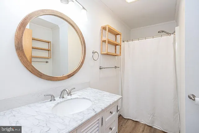 a bathroom with a granite countertop sink a mirror and a shower