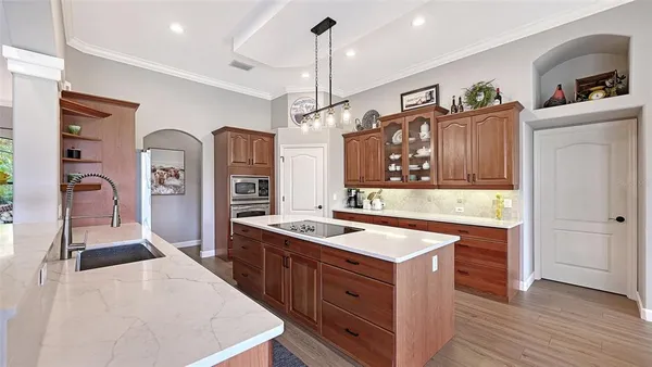 a dining hall with stainless steel appliances granite countertop a stove a sink dishwasher a dining table and chairs with wooden floor