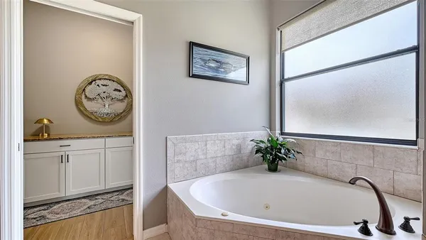 a view of a bedroom with a bed and wooden floor