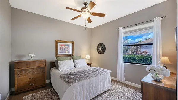 a living room with furniture a ceiling fan and a large window