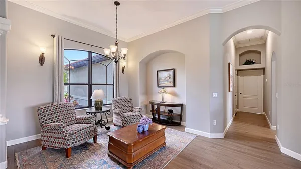 a living room with furniture a fireplace and a chandelier