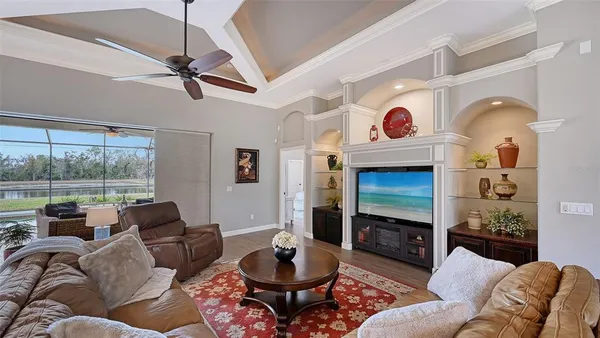 a living room with furniture ceiling fan and a floor to ceiling window